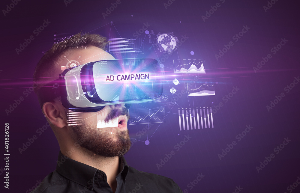 Businessman looking through Virtual Reality glasses with AD CAMPAIGN inscription, new business concept Businessman looking through Virtual Reality glasses with AD CAMPAIGN inscription, new business concept