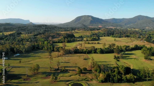 Aerial view of fields and forest, in Nimbin, in the Northern Rivers of New South Wales, Australia - reverse, drone shot photo