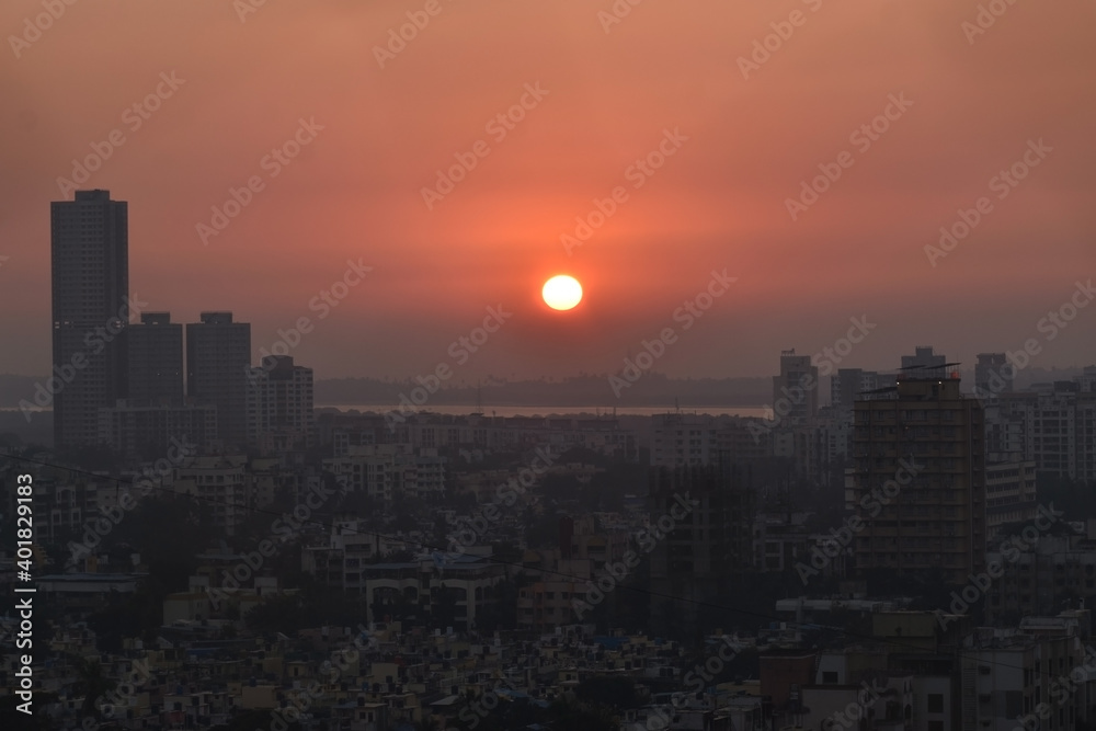 sun sets into arabian sea behind the silhouette city of mumbai borivali ,India ,Maharashtra. Beautiful Sunset with orange sky color . sun sets into arabian sea behind the silhouette city of mumbai borivali ,India ,Maharashtra. Beautiful Sunset with orange sky color .