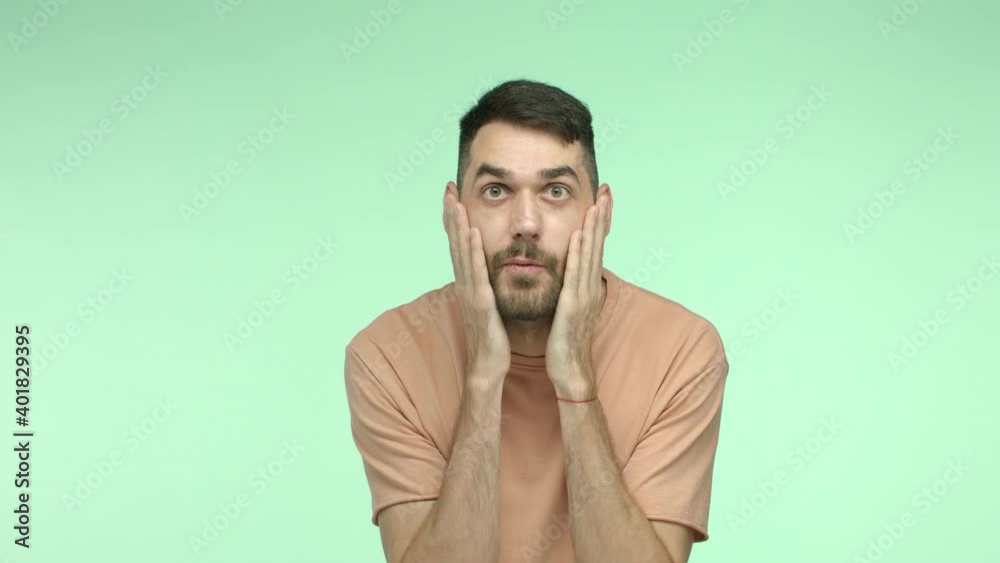 Slow motion of surprised handsome man with beard saying WOW, touching face and shaking head in disbelief, checking out something awesome, looking with awe Slow motion of surprised handsome man with beard saying WOW, touching face and shaking head in disbelief, checking out something awesome, looking with awe
