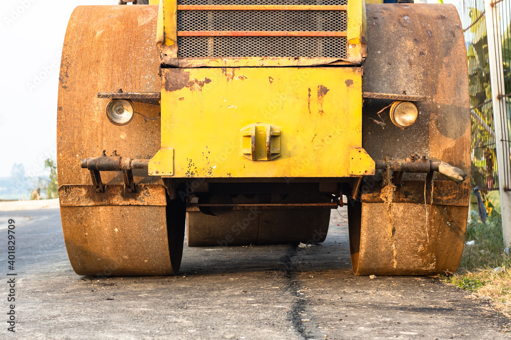 Old rusty yellow road roller front side close view