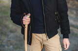 Close-up man hand holding a wooden pole doing trekking in winter season.