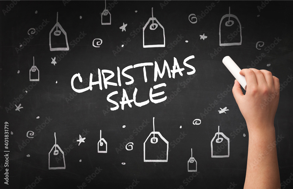 Hand drawing CHRISTMAS SALE inscription with white chalk on blackboard, online shopping concept Hand drawing CHRISTMAS SALE inscription with white chalk on blackboard, online shopping concept