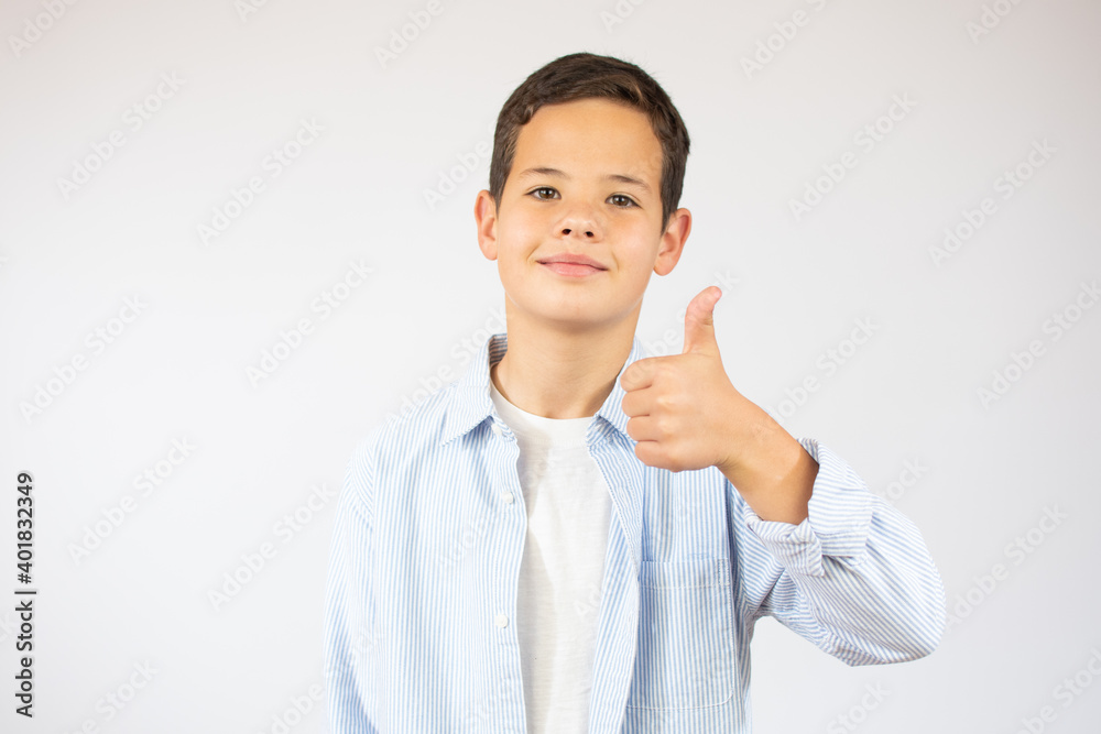 Portrait of happy boy showing thumbs up gesture, isolated white background Portrait of happy boy showing thumbs up gesture, isolated white background