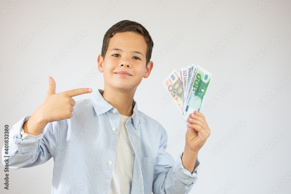 Portrait of a smiling young boy holding money banknotes and celebrating success isolated over white background Portrait of a smiling young boy holding money banknotes and celebrating success isolated over white background