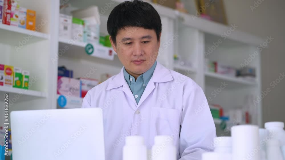 A man pharmacist uses a laptop computer to look at the properties of each drug 4k resolution A man pharmacist uses a laptop computer to look at the properties of each drug 4k resolution