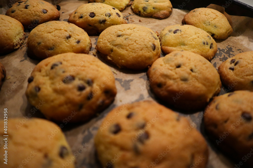 Tasty cookies with chocolate chips on baking tray
