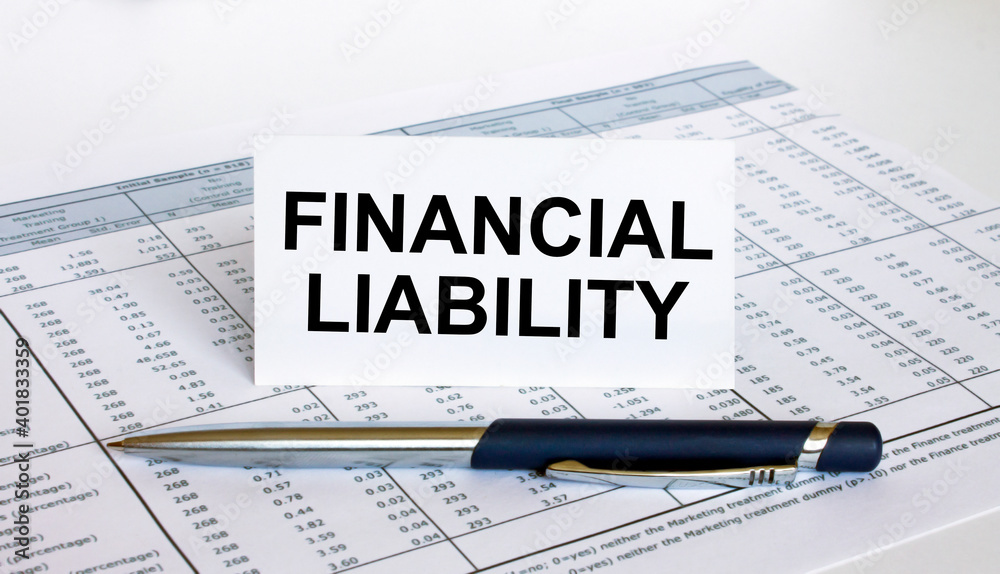 Text Financial Liability on white card with blue metal pen on financial table Text Financial Liability on white card with blue metal pen on financial table