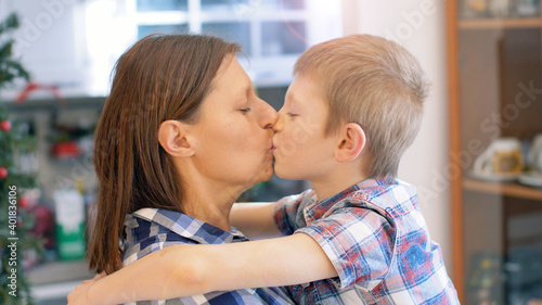 Mother and son are kissing and hugging each other. The relationship between mother and son