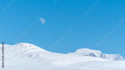 Mountains in winter with the rising full moon in Rondane National Park, Norway