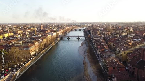 Verona, Italy. Aerial view of famous touristic city Verona in Italy at sunset. Bright sky with illuminated historical buildings.