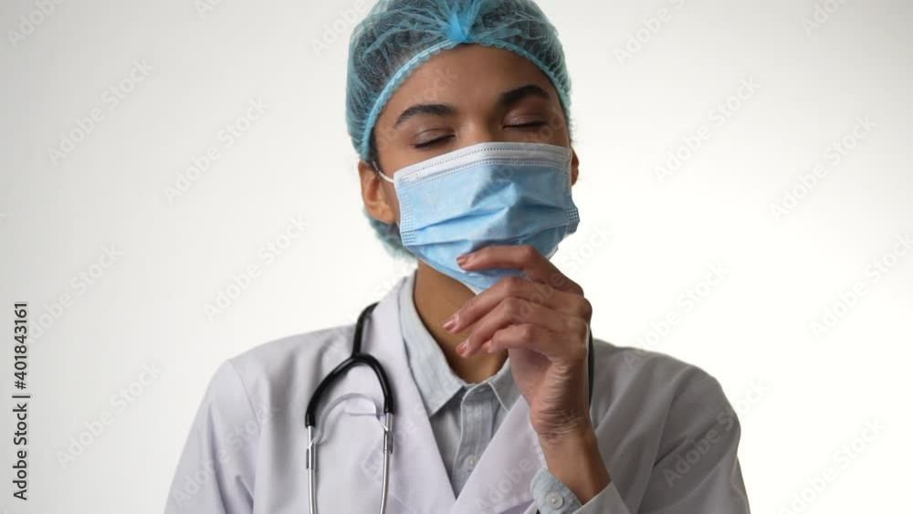 Professional. Attractive young female doctor with stethoscope taking off her medical mask isolated over white background. Healthcare and medicine concept. Slow motion