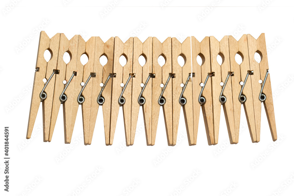 Row of wooden clothespins isolated on white background. A clothespin, or clothes peg is a fastener used to hang up clothes for drying, usually on a clothes line. Row of wooden clothespins isolated on white background. A clothespin, or clothes peg is a fastener used to hang up clothes for drying, usually on a clothes line.