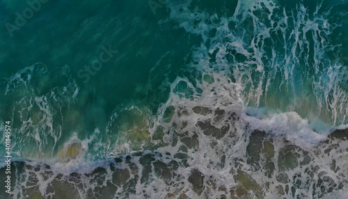 Turquoise ocean water wave view from height to the shining and sparkling surface.