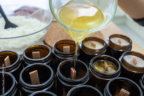 Pouring melted wax. Handmade soy candles with mica and wooden wick. Amber and opaque container. Vegan product without animal cruelty.