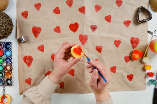 heart shaped potato stamp on craft paper. The process of decorating a gift for Valentine's Day. Getting ready for the celebration on February 14th.