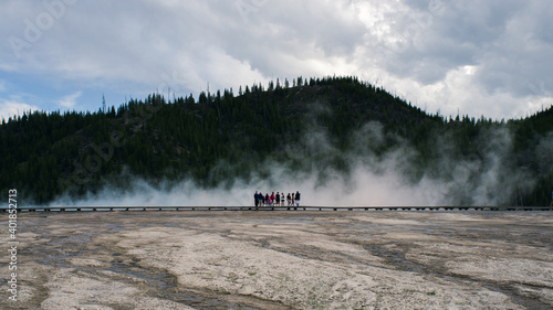 people standing in front of a geyser in yellowstone