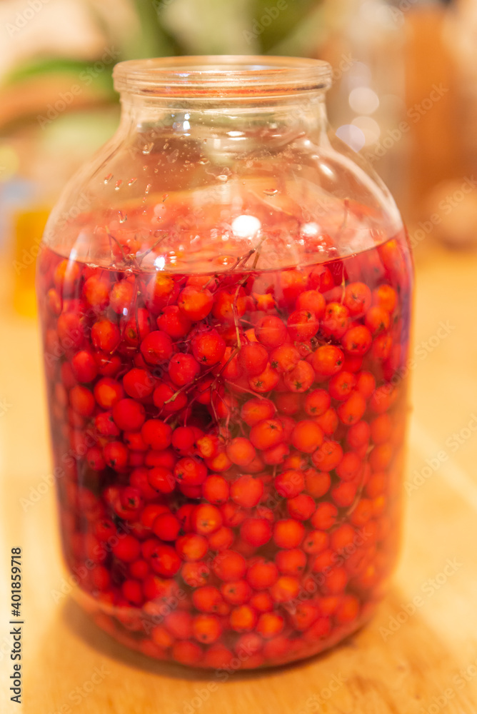 Manufacturer of tincture of mountain ash. Rowan berries in a glass jar. Vodka poured red berries. Manufacturer of tincture of mountain ash. Rowan berries in a glass jar. Vodka poured red berries.
