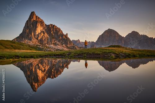 sunrise over a mountain lake with reflections of people and mountains
