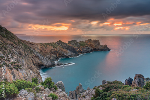 Promontory on the sea at sunset with stormy and colorful sky