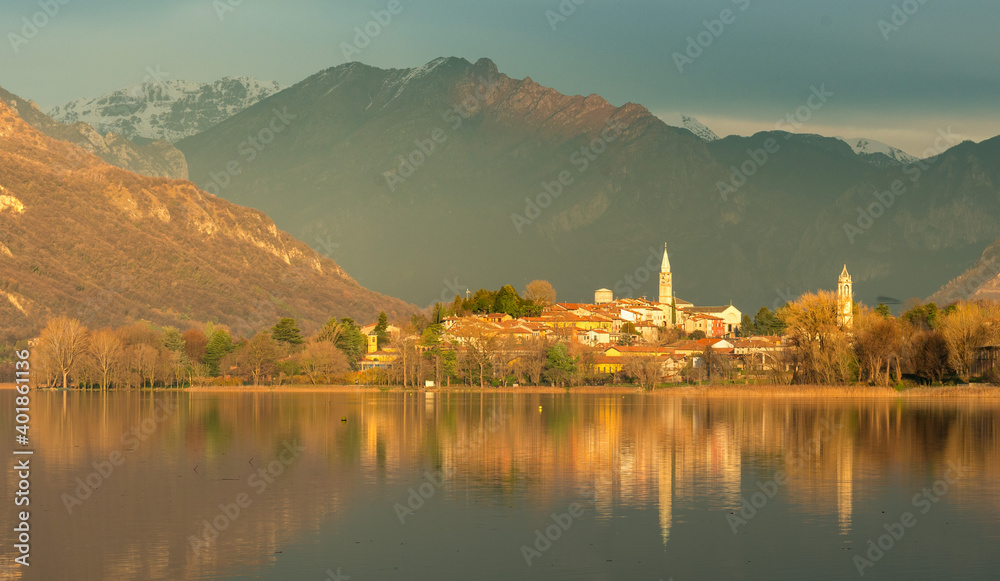 small town reflecting on a lake at sunset with mountains in the background