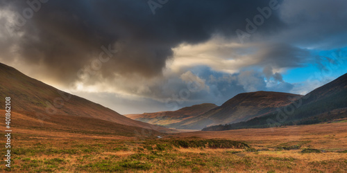 sunset over the mountains with dark clouds on one side in Scotland Isle of Skye 