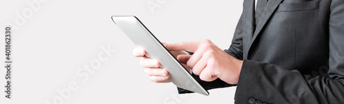 Businessman holding tablet computer and looking on it isolated on a white background