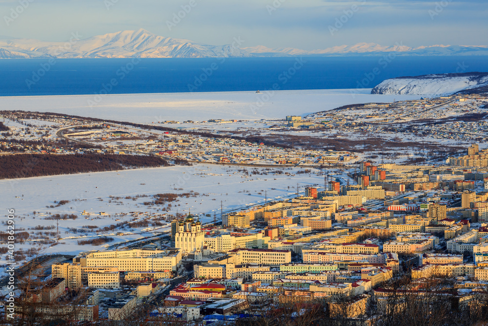 Top view of the city of Magadan. Beautiful cityscape. Magadan is located on the coast of the Sea of ​​Okhotsk. Sea bay and mountains in the distance. Magadan Region, Russia. Russian Far East, Siberia.