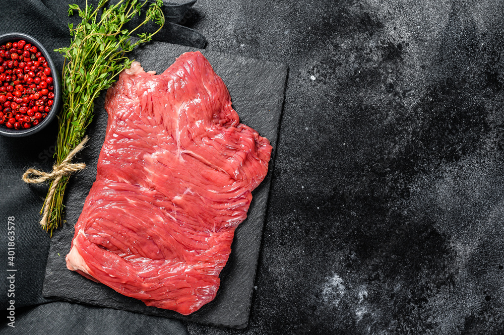 Raw flank steak, marbled meat. Black background. Top view. Copy space
