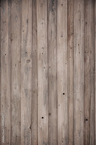 fragment of a fence made of old wooden boards with remnants of paint and nails, natural texture, background