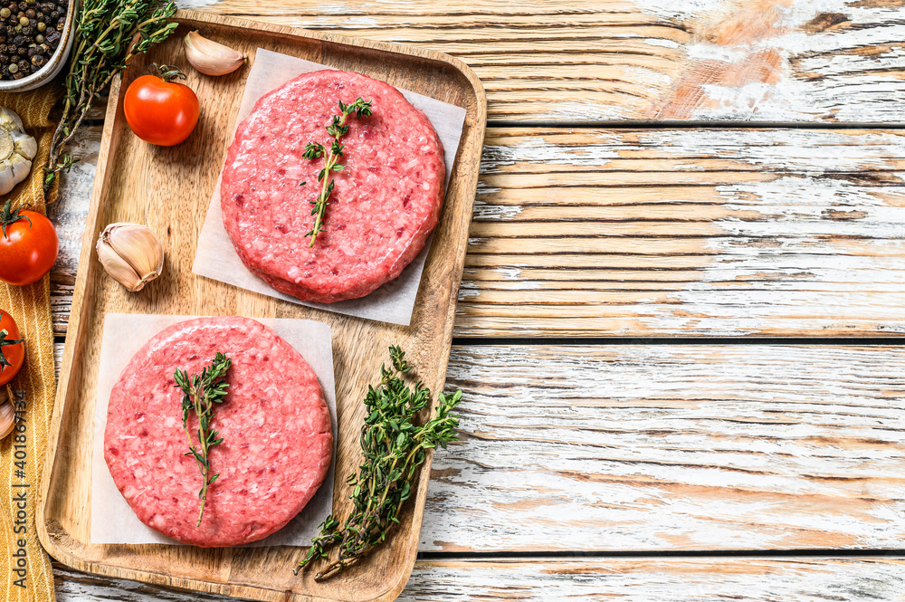 Raw Burger patties. Mince meat cutlet, ground beef and pork.  White background. Top view. Copy space