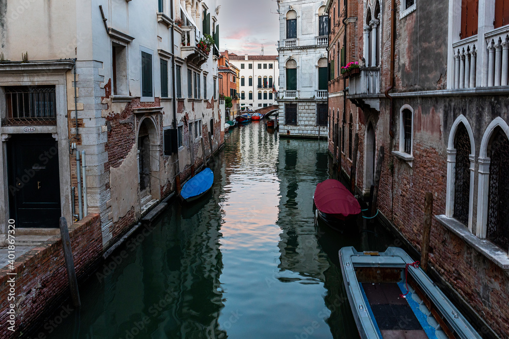 Venice's canal, boat and traditional Venetian houses view.