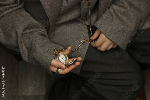 Bild auf Leinwand Young man looking down at gold pocket watch
