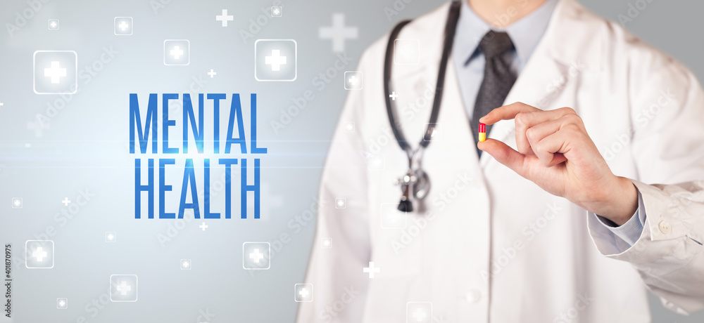 Close-up of a doctor giving a pill with MENTAL HEALTH inscription, medical concept Close-up of a doctor giving a pill with MENTAL HEALTH inscription, medical concept