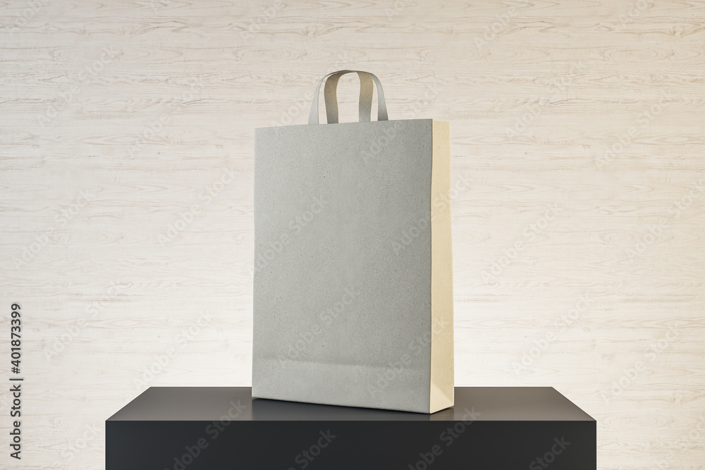 Fototapeta premium Paper bag with handles on podium.