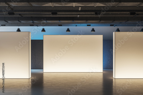 Side view of museum interior with three illuminated banners. photo