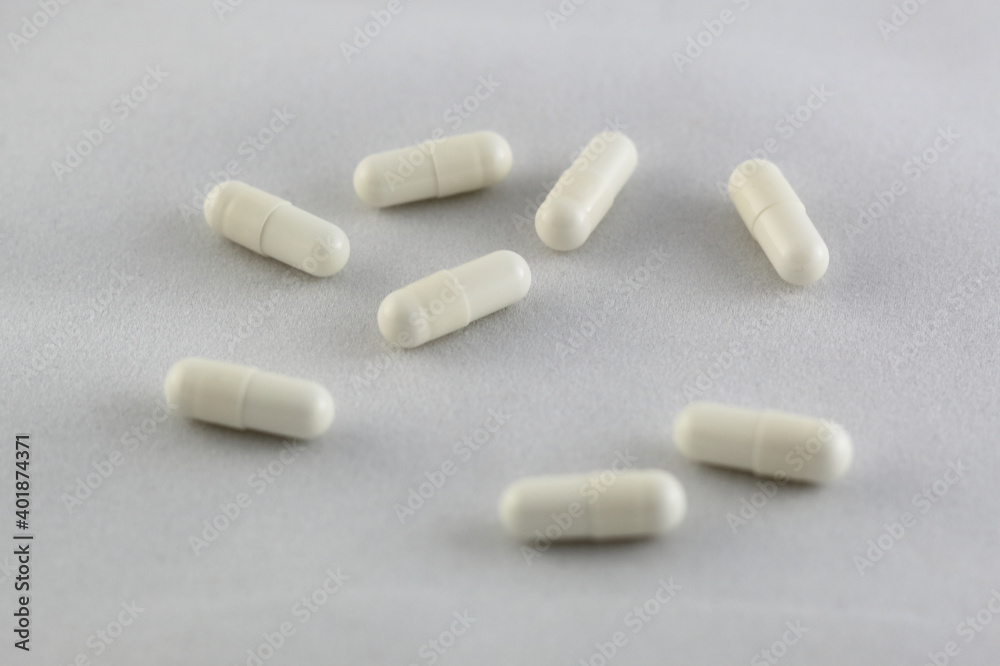 closeup of white pills on white background closeup of white pills on white background