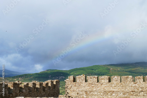 rainbow behind the ruins of the castle of jimena de la frontera photo
