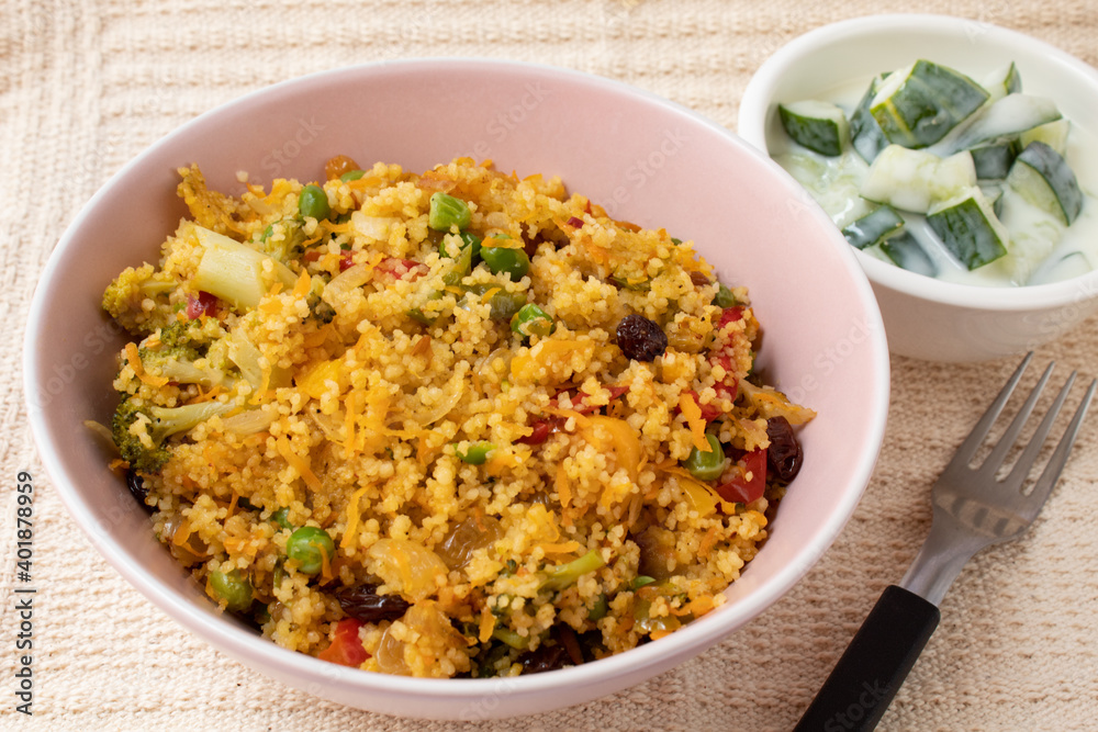 Bowl with Moroccan couscous accompanied by cucumber in yogurt sauce Bowl with Moroccan couscous accompanied by cucumber in yogurt sauce