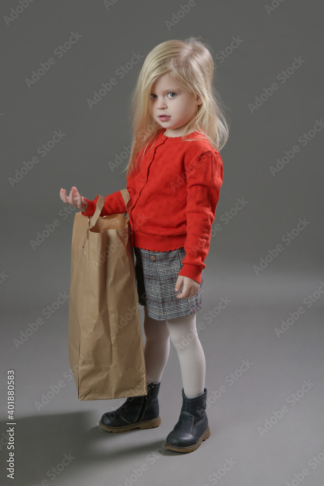 Studio portrait of adorable 3 years old girl holding big blank paper bag. Studio portrait of adorable 3 years old girl holding big blank paper bag.