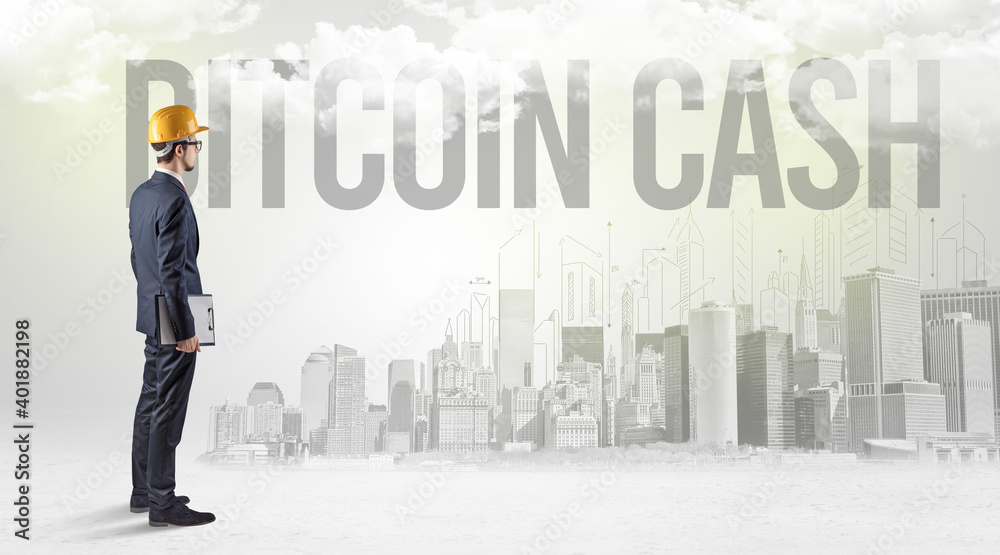 Young businessman with hard hat and BITCOIN CASH inscription, new business opportunity concept Young businessman with hard hat and BITCOIN CASH inscription, new business opportunity concept