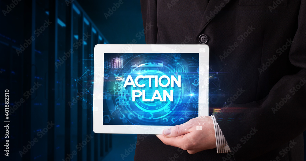 Young business person working on tablet and shows the inscription: ACTION PLAN, business concept Young business person working on tablet and shows the inscription: ACTION PLAN, business concept