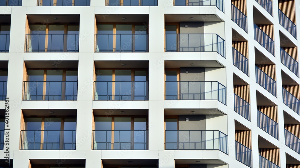 Facade of new apartment building. Glass balcony and clean look of modern architecture building with blue sky background. Facade of new apartment building. Glass balcony and clean look of modern architecture building with blue sky background.