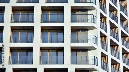 Facade of new apartment building. Glass balcony and clean look of modern architecture building with blue sky background.
