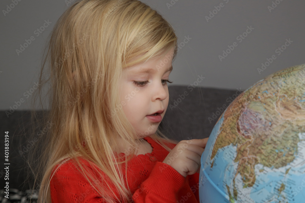 Portrait of adorable 3 years old girl playing with a globe. Portrait of adorable 3 years old girl playing with a globe.