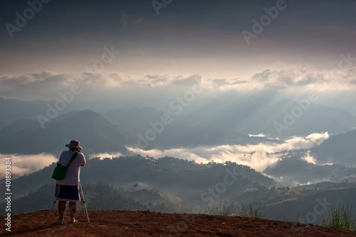 A photographer is taking a photo of  foggy mountain landscape in a morning  Thailand