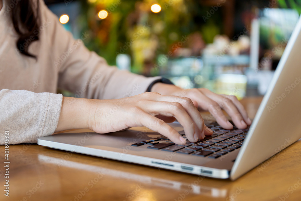 Fototapeta premium Happy Asian woman concentrated working in the coffee shop by using laptop computer.