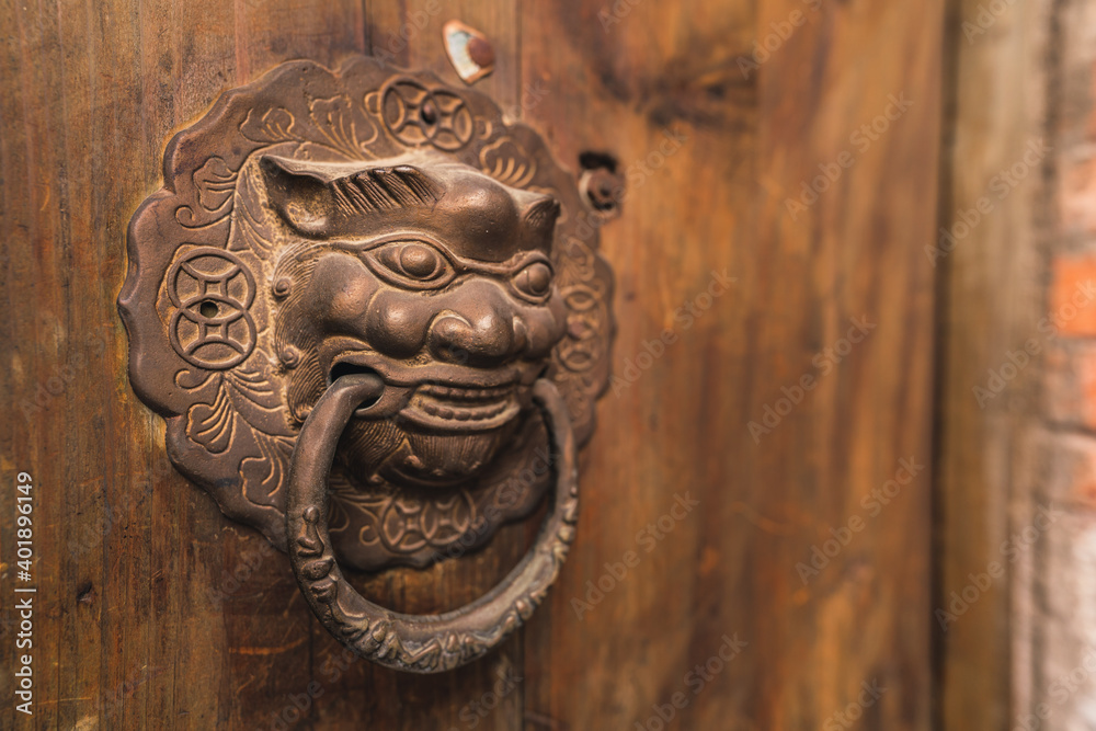 Retro lion head iron door knocker on ancient Chinese wooden door