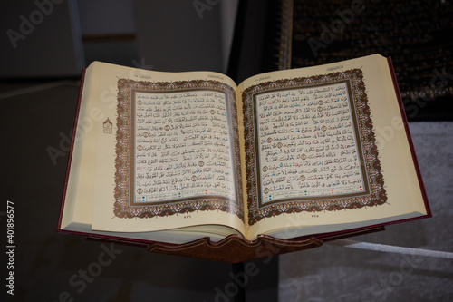 A closeup of an opened Quran book on the bookholder photo