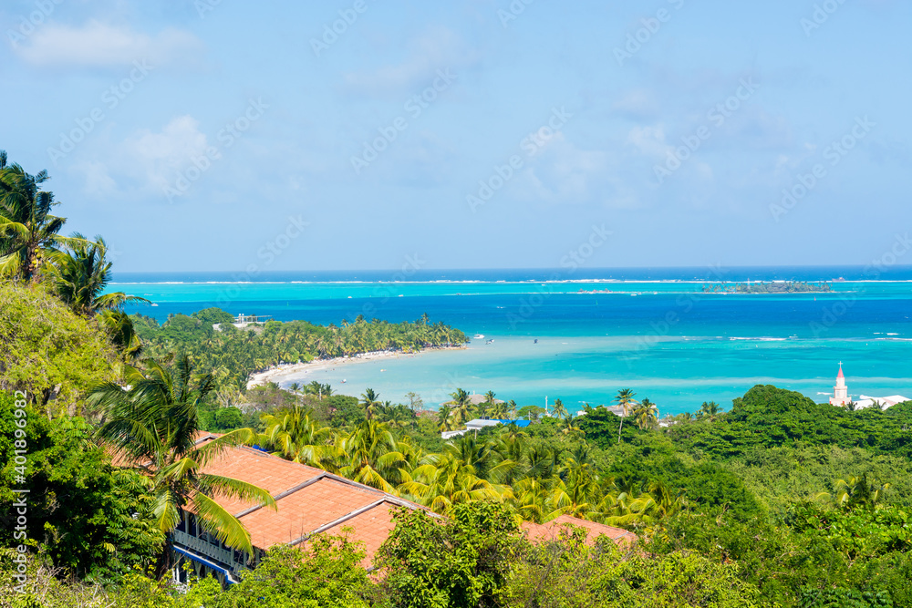 Landscape of the beach of San Andres island and Providencia Archipelago in Colombia with blue ocean and green palms and vegetation with boats and tourists  